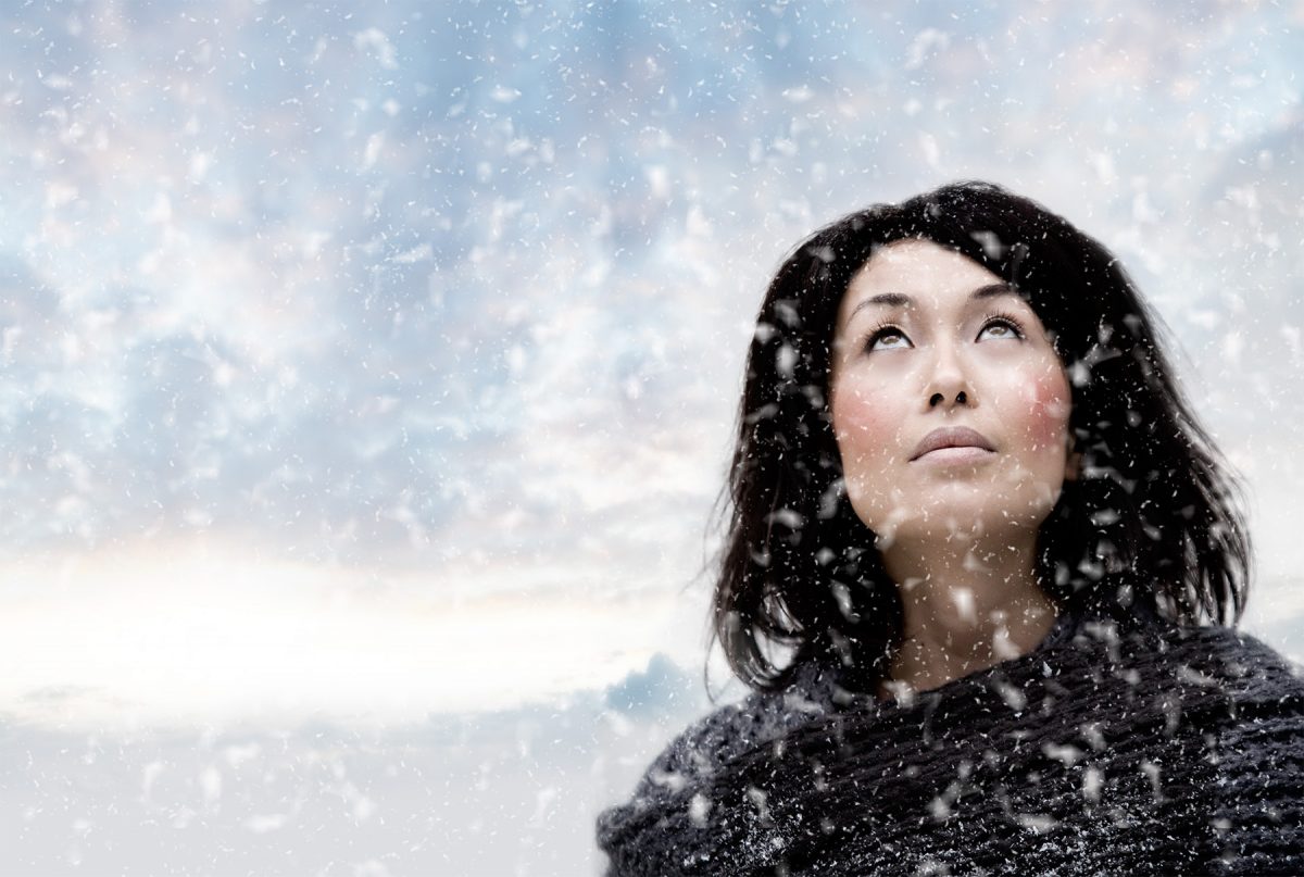 junge Frau vor dramatischem Himmel im Schnee People Fotografie
